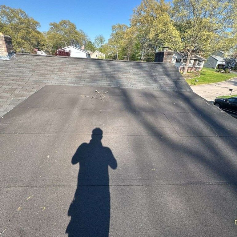 energy efficient roofing trends 2026 Modern energy-efficient residential roofing system installed in 2026 with flat roof membrane and asphalt shingles
