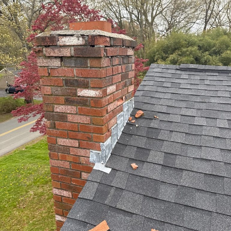 spalling brick chimney roof damage Spalling brick chimney repair needed after deteriorated bricks fell onto an asphalt shingle roof