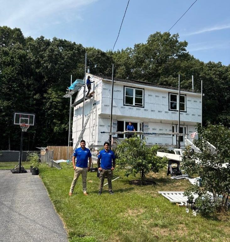 house wrap and roof integration Professional roofing crew completing house wrap and roof integration during residential exterior construction.