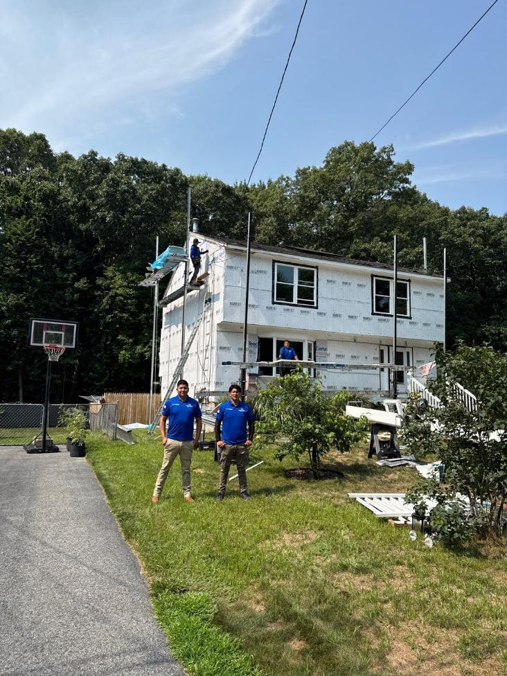 house wrap and roof integration Professional roofing crew completing house wrap and roof integration during residential exterior construction.